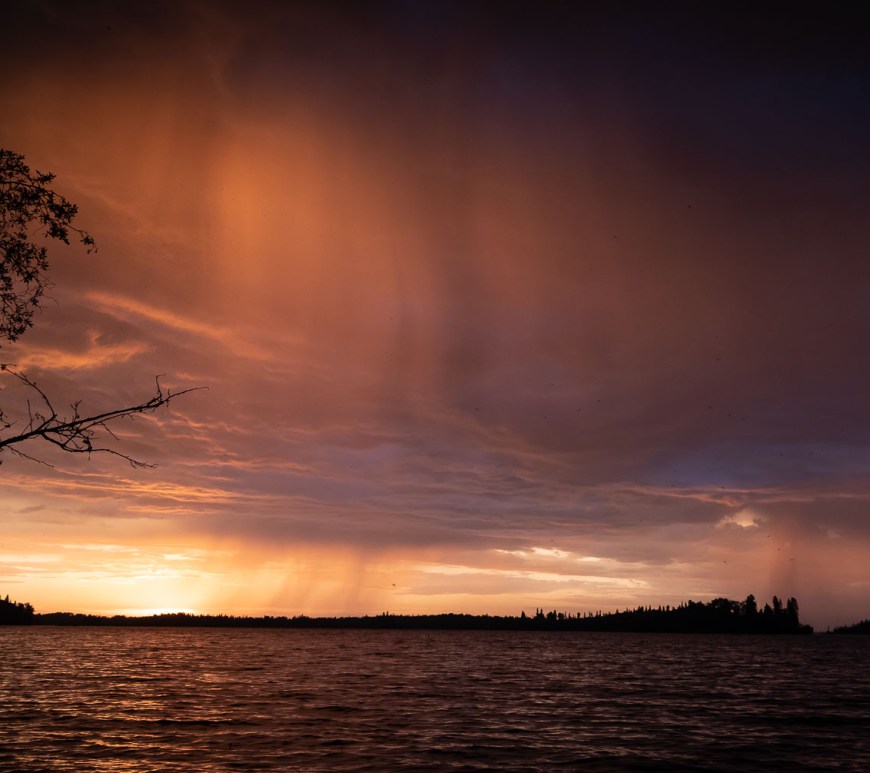 The sun sets before the rains fall upon the lake.
