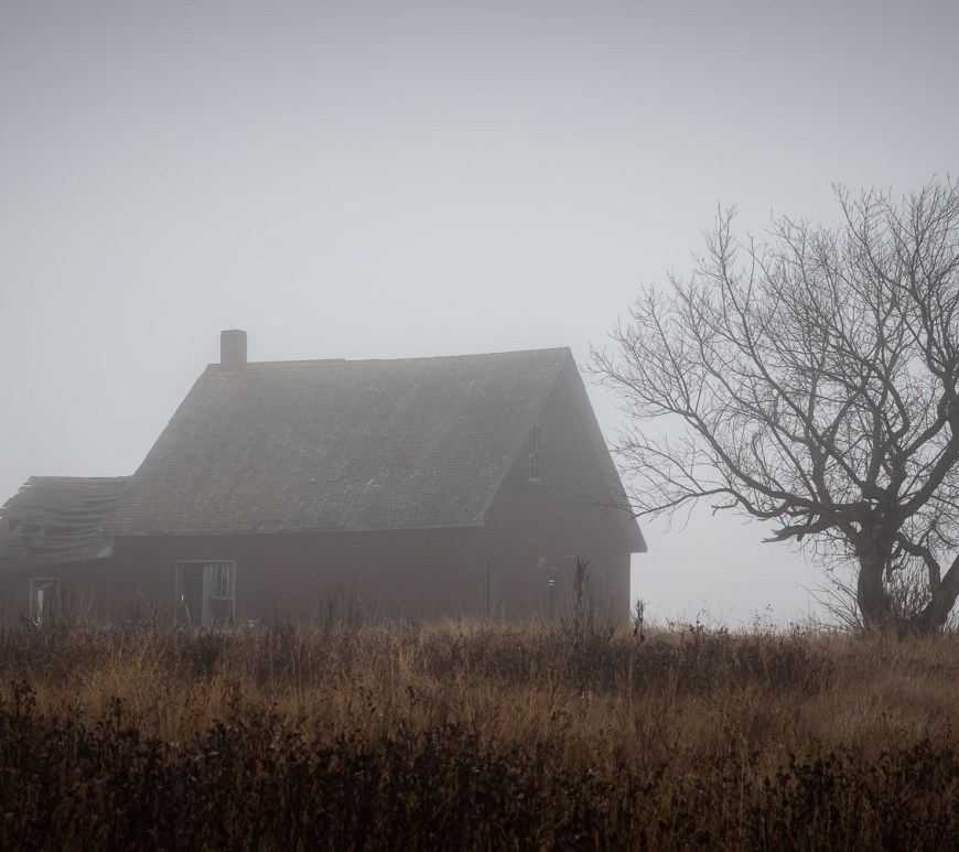 A lonely house sits in the foggy horizon