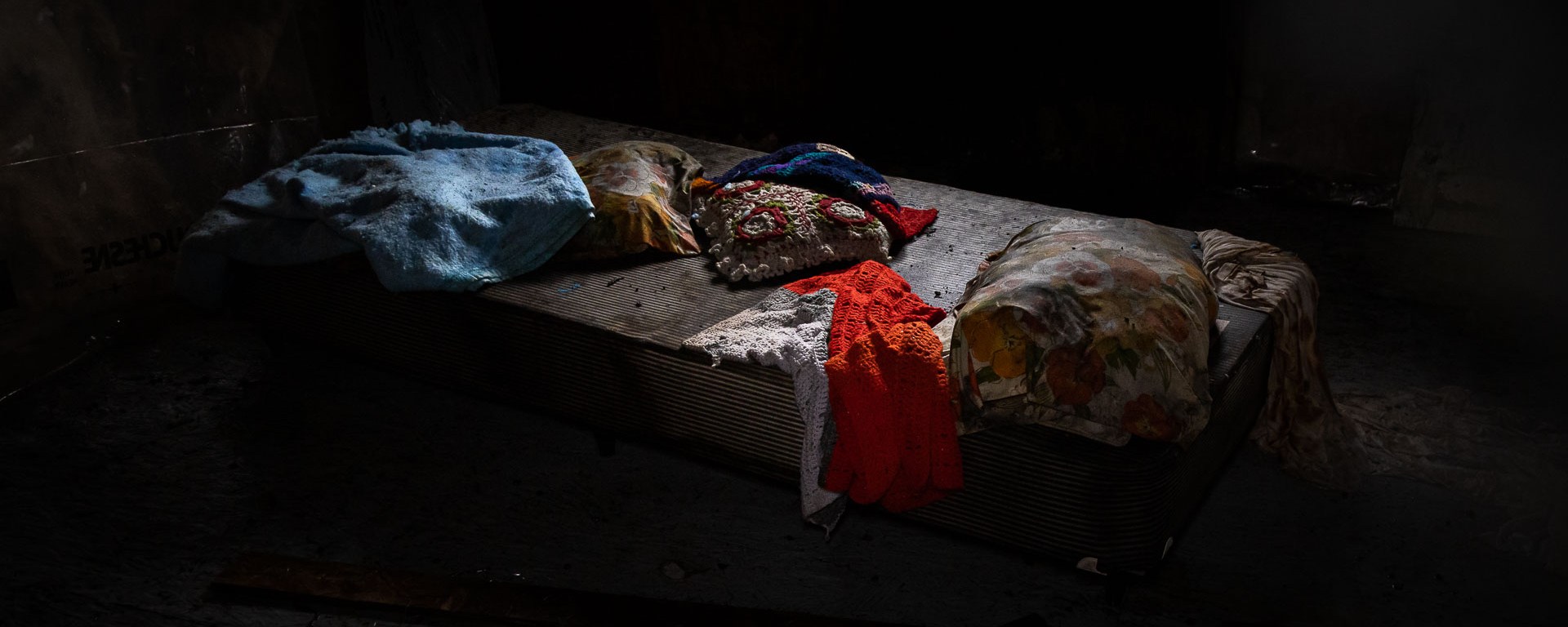 A single bed adorned in homemade blankets