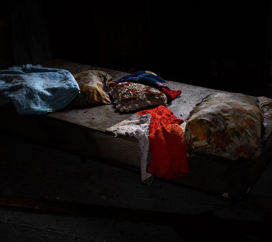 A single bed adorned in homemade blankets