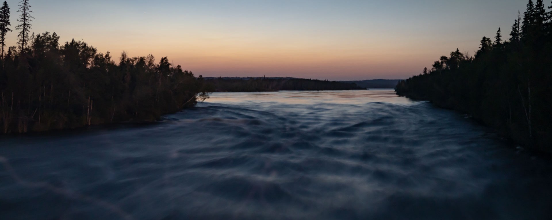 Rapid waters rush forward at sunset.
