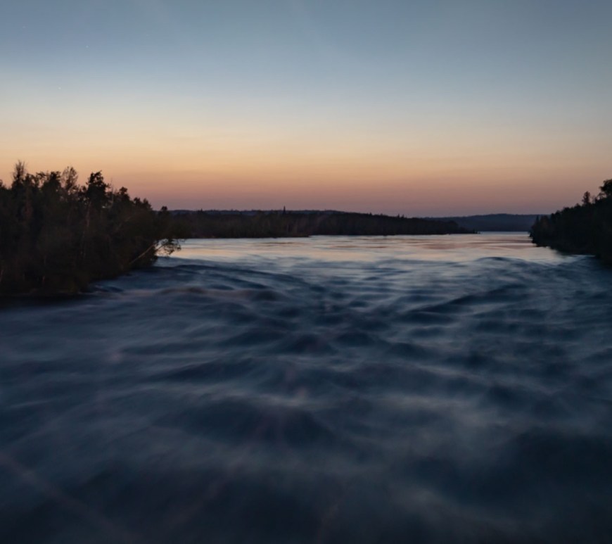 Rapid waters rush forward at sunset.