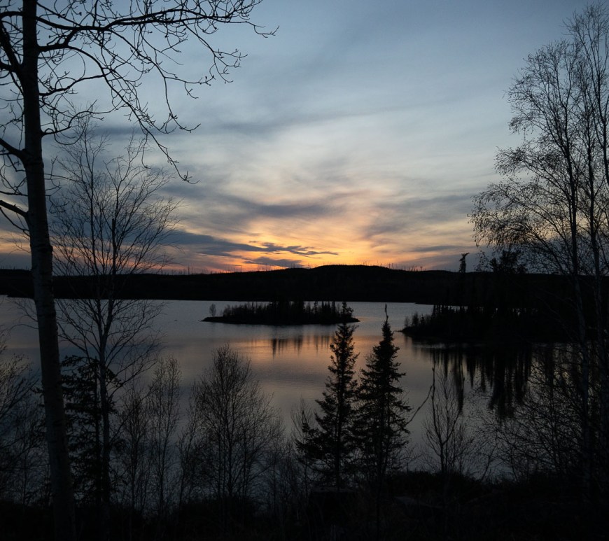 The sunsets behind a lake.