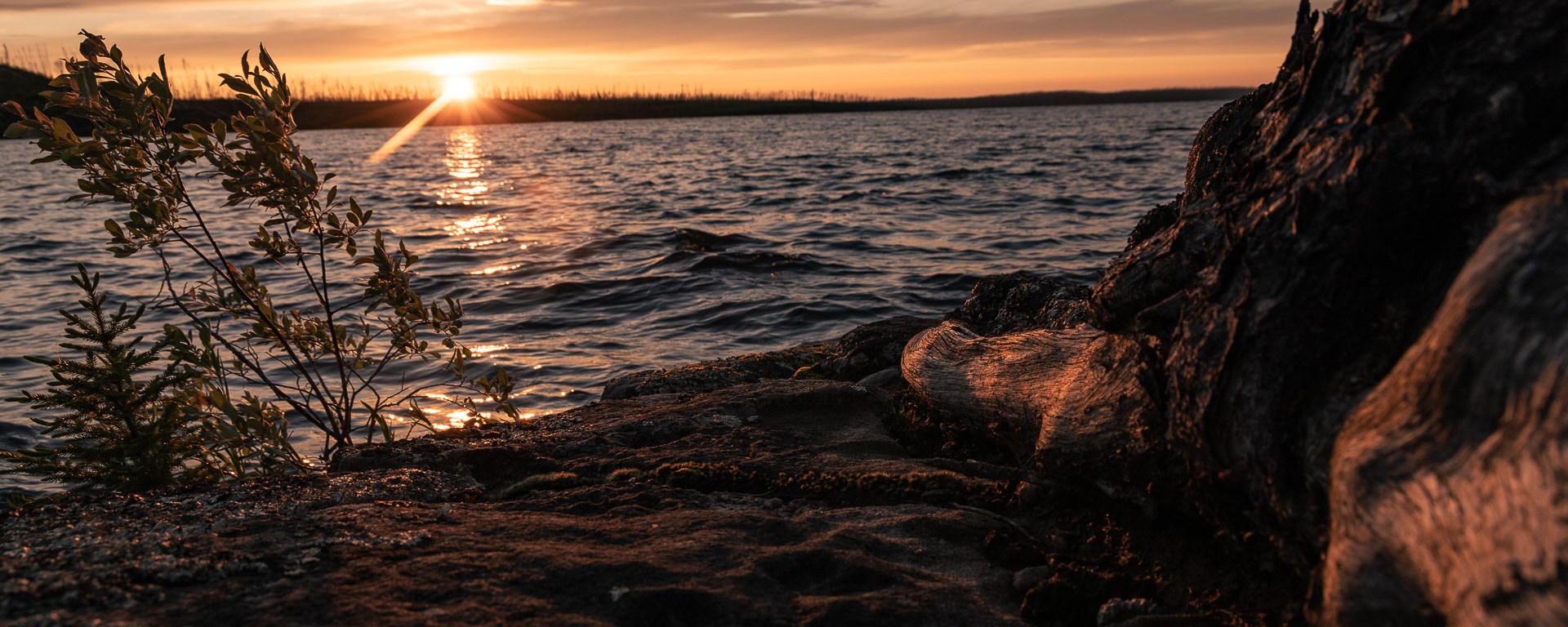 Sun setting behind the horizon of the lake.