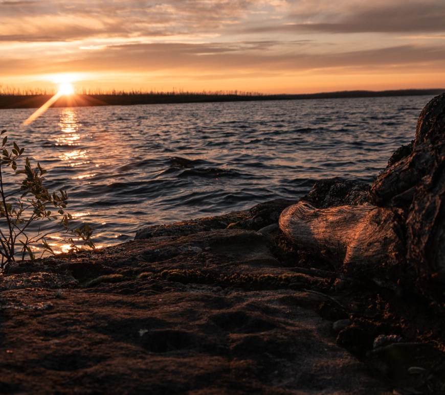 Sun setting behind the horizon of the lake.
