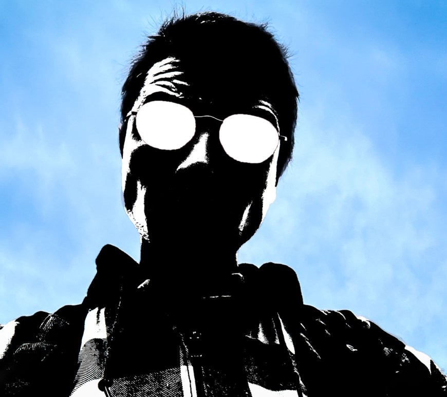 A mostly hidden face peers down into the camera.