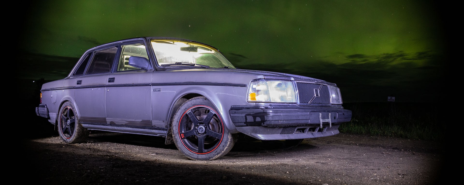 Volvo 240 posed in front of northern lights.
