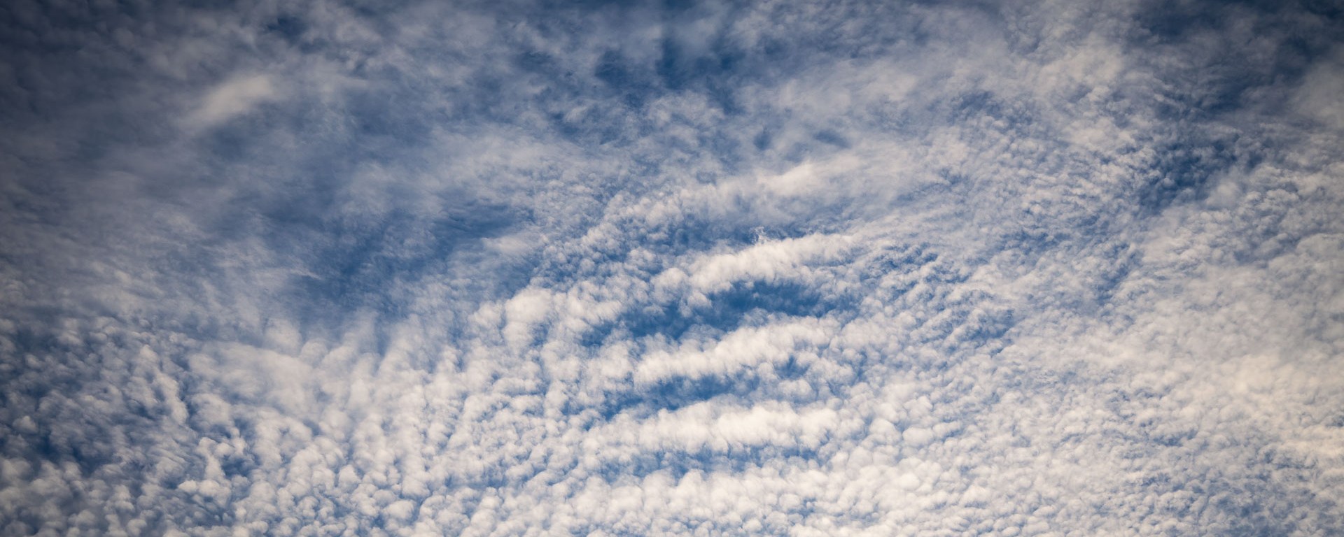 Cloudy wisps cover clear blue skies.
