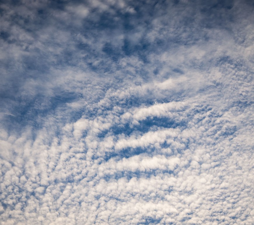 Cloudy wisps cover clear blue skies.